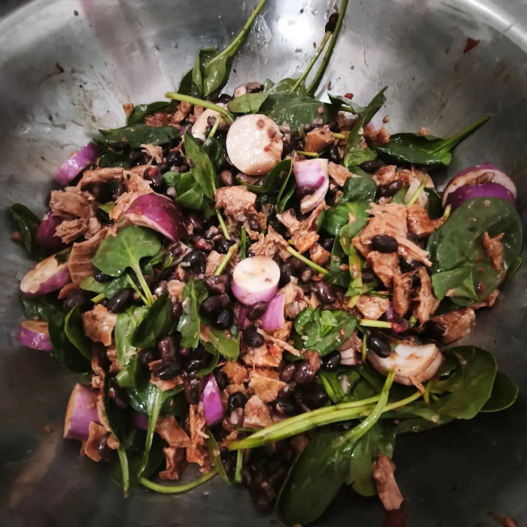 Salada de folhas verdes com cebola roxa numa taça de inox